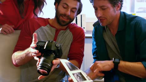 Male-graphic-designers-showing-pictures-to-his-coworkers-on-camera
