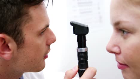 Optometrista-Examinando-A-Una-Paciente-A-Través-Del-Oftalmoscopio