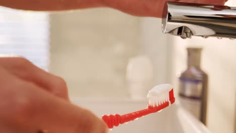 Man-putting-toothpaste-on-toothbrush