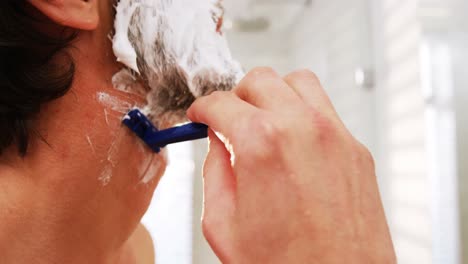 Man-using-a-razor-to-shave-his-beard-off