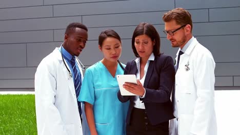 Team-of-doctors-discussing-over-digital-tablet