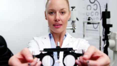 Smiling-female-optometrist-holding-messbrille