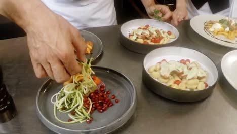 Mid-section-of-chefs-garnishing-food