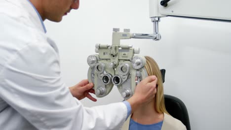 Lächelnder-Optiker-Untersucht-Patientin-Am-Phoropter
