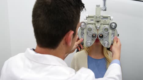 Optometrista-Sonriente-Examinando-A-Una-Paciente-Con-Foróptero