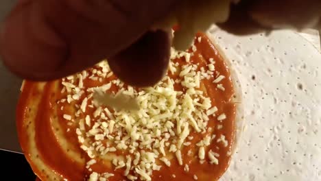 Hand-of-chef-pouring-grated-cheese
