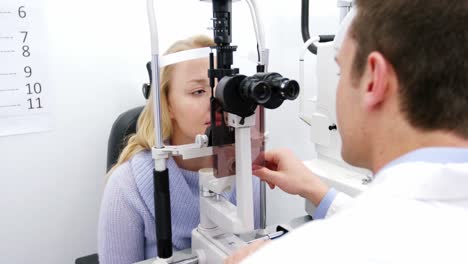 Optometrist-examining-female-patient-on-slit-lamp
