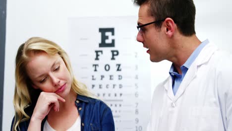 Optometrist-discussing-eye-test-report-of-female-patient
