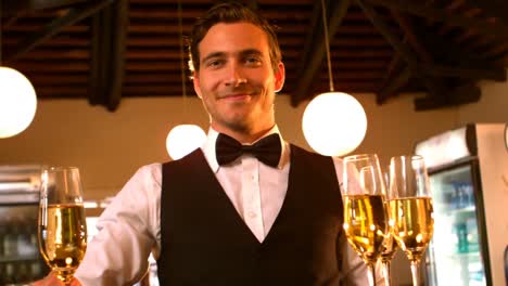Male-waiter-serving-a-glass-of-champagne
