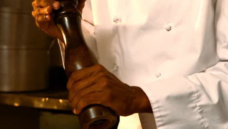 Chef-using-pepper-grinder