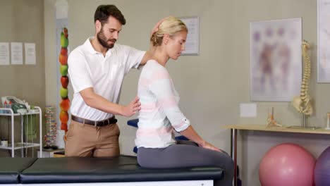 Männlicher-Physiotherapeut,-Der-Einer-Patientin-Eine-Rückenmassage-Gibt