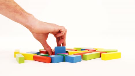 Man-hand-playing-building-blocks