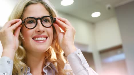 Smiling-female-customer-trying-spectacles
