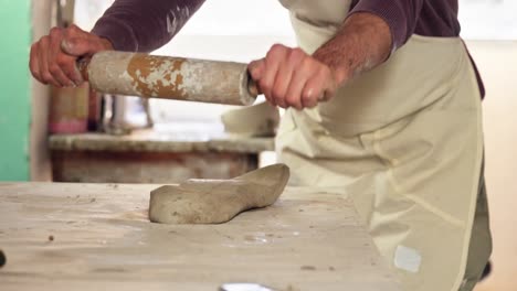 Male-potter-molding-clay-with-rolling-pin