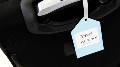 Travel-insurance-label-tied-to-a-suitcase