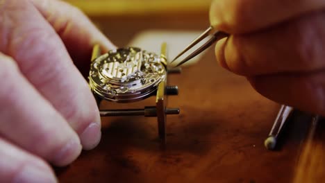 Close-up-of-horologist-hands-repairing-a-watch