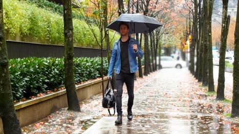 Mann-Hält-Einen-Regenschirm-Und-Geht-Auf-Der-Straße