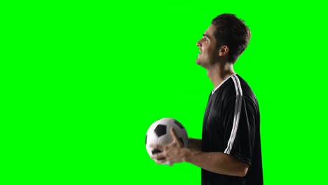 Football-player-holding-a-football-against-green-screen