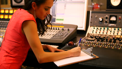 Female-audio-engineers-writing-on-clipboard