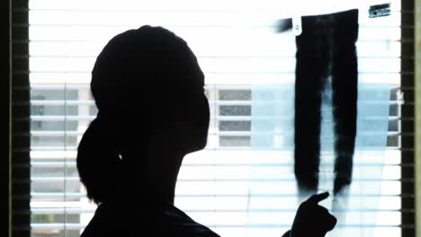 Silhouette-of-female-doctor-checking-x-ray-report