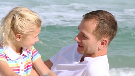 Close-up-of-father-talking-to-his-daughter-on-the-beach