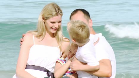 Close-up-of-happy-family-sitting-on-the-beach