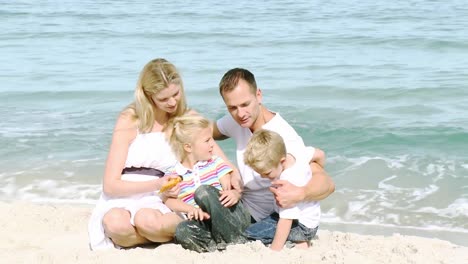 Glückliche-Familie,-Die-Am-Strand-Sitzt