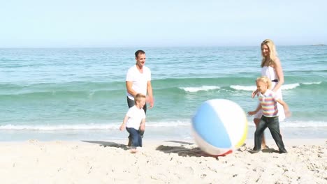Familie-Spielt-Mit-Einem-Ball-Im-Sand