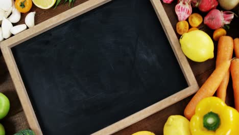 Zoom-on-chalkboard-surrounded-with-fresh-vegetables-and-fruits-