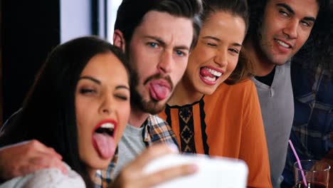Friends-making-funny-faces-and-taking-a-selfie-on-mobile-phone