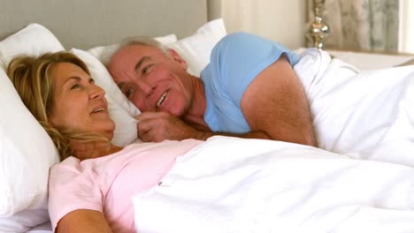 Happy-senior-couple-interacting-with-each-other-on-bed
