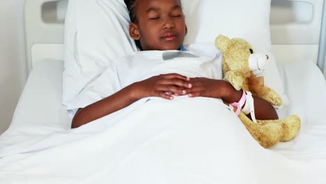Sick-girl-resting-with-teddy-bear-on-bed