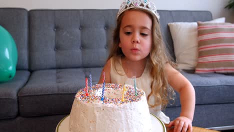 Mädchen-Bläst-Kerzen-Auf-Geburtstagstorte
