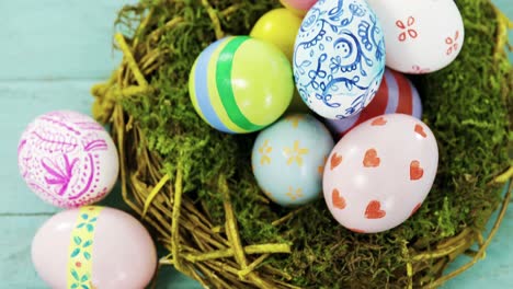Painted-Easter-eggs-in-the-nest-on-wooden-surface