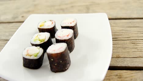 Sushi-Maki-Servido-En-Un-Plato-Sobre-Fondo-De-Madera
