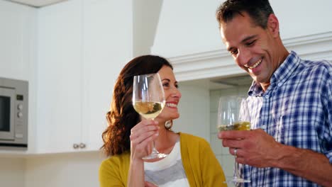 Glückliches-Paar,-Das-In-Der-Küche-Mit-Gläsern-Wein-Anstößt