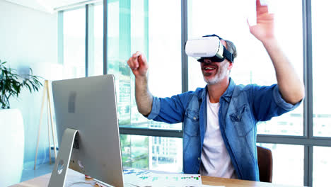 Male-executive-using-virtual-reality-headset-at-desk