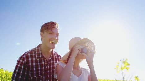 Couple-taking-picture-from-camera-in-mustard-field