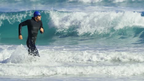 Surfista-Masculino-Corriendo-En-La-Playa