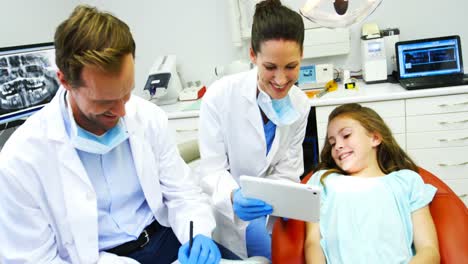 Dentist-showing-digital-tablet-to-young-patient