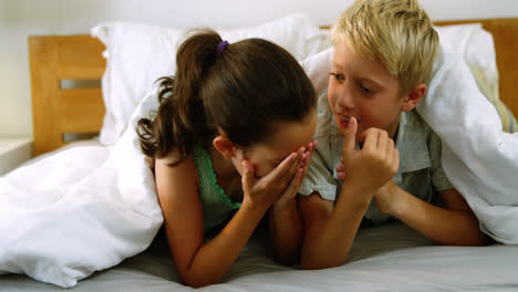 Siblings-interacting-with-each-other-on-bed-in-bedroom