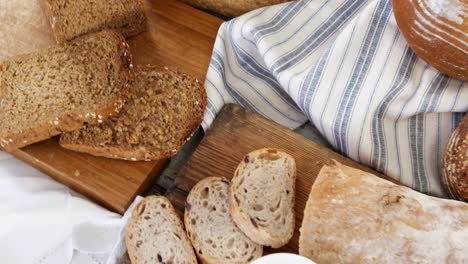 Various-bread-loaves-with-butter-on-wooden-table