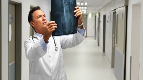 Male-doctor-examining-x-ray-in-corridor