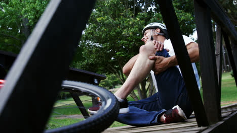 Fallen-cyclist-holding-his-injured-knee
