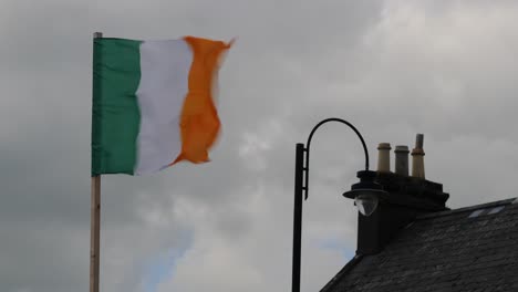Schneller-Irischer-Flaggentanz-Inmitten-Bewölktem-Himmel-Und-Traditionellem-Dach