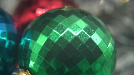 Christmas-holiday-decoration,-colorful-crystal-ornaments-colorful-balls-on-a-360-rotating-stand-new-year-decorated,-shiny-lights,-cinematic-Macro-pan-right-follow-4K-video,-beautiful-depth-of-field