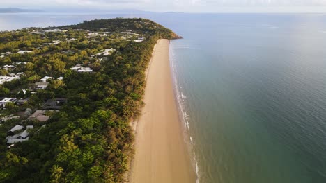 Scenic-drone-view-of-Four-Mile-Beach-in-the-town-of-Port-Douglas-looking-to-Flagstaff-Hill-and-Daintree-Mountain-Range