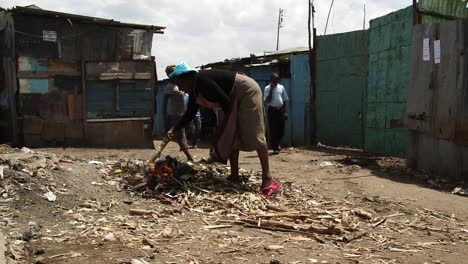 Mujer-Quemando-Basura-En-Un-Barrio-Pobre-De-Kenia.