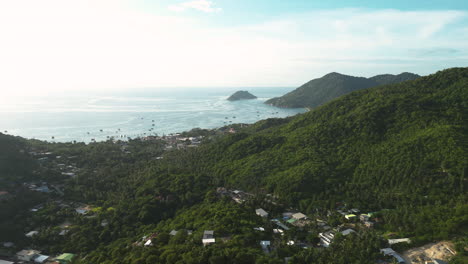 Koh-Tao-mountains-with-jungle-forest-and-villages-in-Thailand,-aerial-drone-view