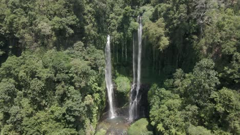 Aerial-approaches-Sekumpul-waterfall-flowing-out-of-jungle-cliff,-Bali